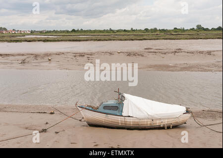 marooned sailing boat boats raised up on silty mud and sand at low tide on backwaters of estuary at he Hythe Quay Maldon Stock Photo