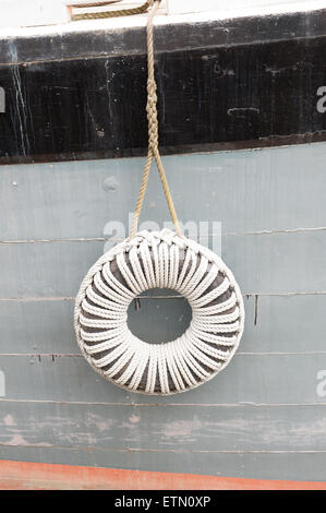 like a hanging polo mint the neat hanging boat fender protects a painted wooden sailing barge hull Stock Photo