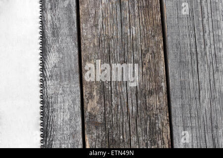 Handsaw and  measuring tape on a wooden board with copyspace, closeup Stock Photo