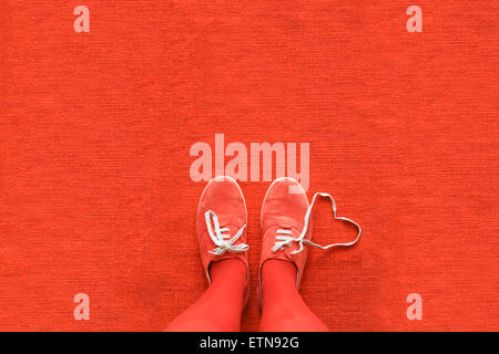 Knees down view of a woman's legs with a heart made out her shoelaces Stock Photo
