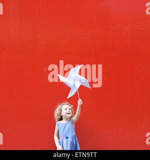 Smiling girl holding a pinwheel in the air making a Hong Kong flag Stock Photo
