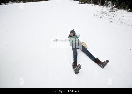 Smiling woman lying in snow, Wyoming, USA Stock Photo