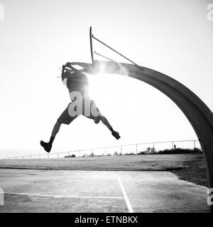 Young man shooting hoops in a park, Los Angeles, California, USA Stock Photo