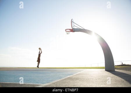 Young man playing basketball in a park, Los Angeles, California, United States Stock Photo
