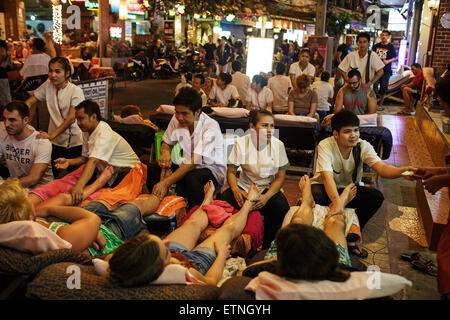 Foreign tourists having massage at night on Soi Rambuttri in Khao San road area of Bangkok, Thailand. Stock Photo