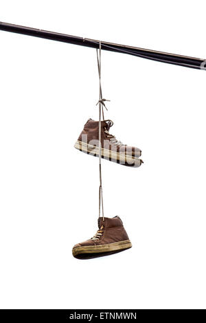 Shoe Tossing, Old Sneakers Hanging on Powerline Wire, Isolated on White Background Stock Photo