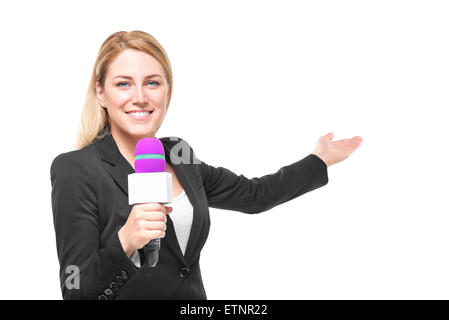 Attractive blonde TV presenter holding a microphone and points to an object. Isolated on white background. Stock Photo