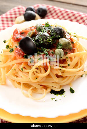 linguine pasta with tomato sauce and black olives and capers Stock Photo