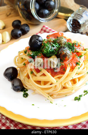 linguine pasta with tomato sauce and black olives and capers Stock Photo