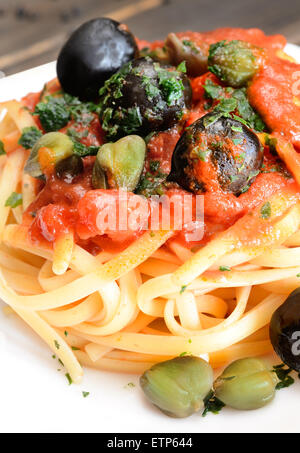 linguine pasta with tomato sauce and black olives and capers Stock Photo