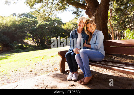 beautiful mother and daughter relaxing on park bench Stock Photo