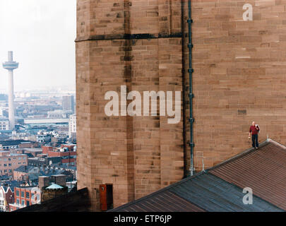 Tony Baker stonemason is the first stonemason to be employed full time at Liverpool Anglican Cathedral since work on the West End was completed in 1978. Pictured on the roof of the Anglican Cathedral, with the St John's Beacon in the background. 8th March Stock Photo