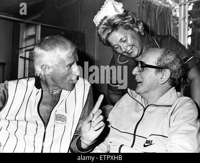 Jimmy Savile visits his brother Vince Savile while Sister Margaret Lloyd looks on. Vince was transferred to Rookwood Hospital, Llandaff, a fortnight ago following surgery to remove a brain tumour at Leeds General Infirmary. 23rd August 1984. Stock Photo