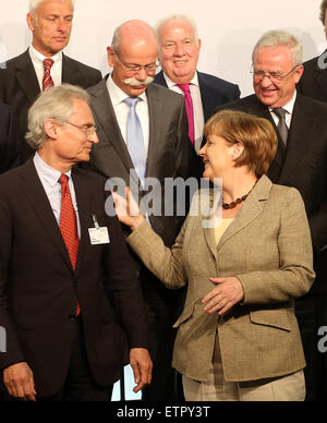 German Chancellor Angela Merkel poses with representatives of the major DAX30 companies and conference participants for a group picture as she attends the national conference of the German government on electric mobility in Berlin, Germany, 15 June 2015. Mercedes-Benz CEO Dieter Zetsche (L) and Volkswagen Group CEO Martin Winterkorn (R) are pictured standing behind Merkel. PHOTO: WOLFGANG KUMM/dpa Stock Photo