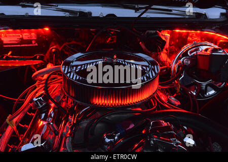 Bellmore, New York, USA. 12th June, 2015. Under an open hood, the engine of a red 1972 Pontiac Convertible LeMans Sport is lit up in red at the Friday Night Car Show held at the Bellmore Long Island Railroad Station Parking Lot. Hundreds of classic, antique, and custom cars were on view at the free weekly show, sponsored by the Chamber of Commerce of the Bellmores. © Ann Parry/ZUMA Wire/Alamy Live News Stock Photo