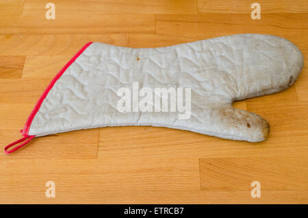 Old kitchen glove isolated on a wood table Stock Photo
