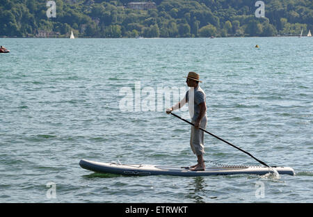 Stand up paddle surfing or standing paddle boarding on Lake Annecy in France Stock Photo