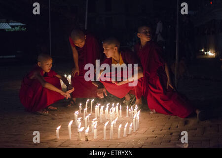 June 12, 2015 - Kathmandu, Nepal - Buddhist monks talk in front of candles during a mass gathering and candlelight vigil held at Boudhanath Stupa. The massive earthquake which struck Nepal on April 25 and ensuing aftershocks have left nearly 9,000 people dead and destroyed or damaged tens of thousands of houses in Nepal. (Credit Image: © Sumit Shrestha/ZUMA Wire/ZUMAPRESS.com) Stock Photo