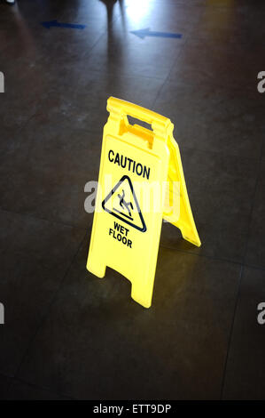 Caution yellow sign for wet floor warning on a floor Stock Photo