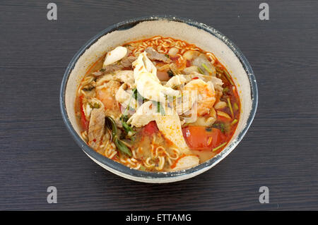 Asian spicy seafood noodle soup, Thai style instant seafood noodle soup, in ceramic bowl Stock Photo