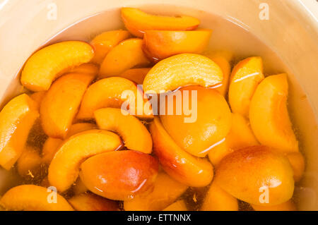 Bowl of fresh sliced yellow peaches in a bowl of clear syrup Stock Photo