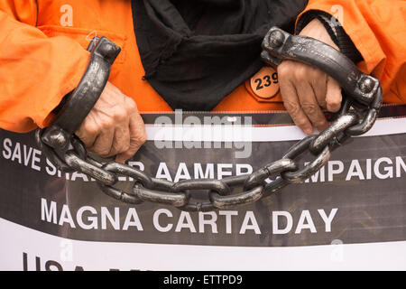 London, UK. 15th June, 2015. Protesters don orange jumpsuits on Whitehall opposite Downing Street as they demand the release of Shaker Aamer, the last British resident to be held in detention in Guantanamo bay. © Patricia Phillips/Alamy Live News Stock Photo