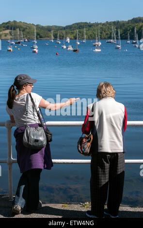 Two ladies/ women talking/ chatting and leaning on the rail at Tobermory Isle of Mull Inner Hebrides Argyll Scotland Stock Photo