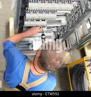 Worker in a switchboard construction factory Stock Photo