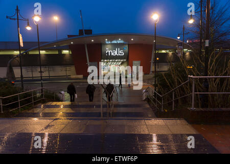 Commuters at dawn in Basingstoke walking through the morning rain into the town centre from the train station. Hampshire, UK Stock Photo