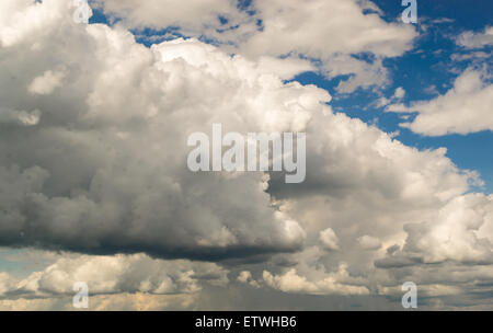 Rolling gigantic grey clouds gather in a blue sky Stock Photo