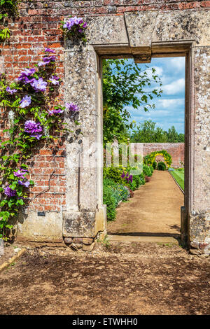 View through a gateway to a herbaceous border in the walled garden of Bowood House. Stock Photo
