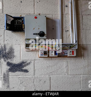 vandalized switchgear in an abandoned factory with exposed wires, Stock Photo
