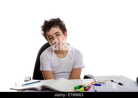 Tired  boy doing his  homework: he is sadly sitting in front of books,copybooks and pencils Stock Photo