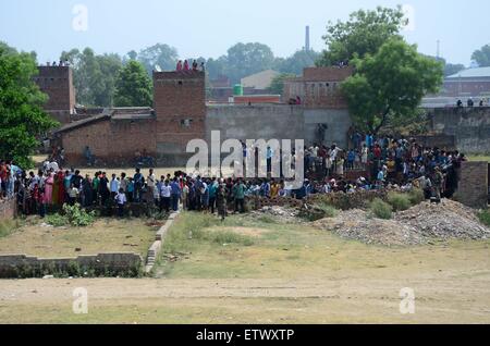 Allahabad, India. 16th June, 2015. People gather near a Jaguar fighter aircraft of the Indian Air Force crashed this morning at Chaka in Naini near Allahabad in Uttar Pradesh. Both the pilots managed to eject safely. The plane which had taken off at 7:25 am from the Bamrauli air strip in Allahabad was on a routine training sortie. The pilots reportedly sent signals to the ground staff that there was some major technical glitch with the aircraft. Credit:  PACIFIC PRESS/Alamy Live News Stock Photo