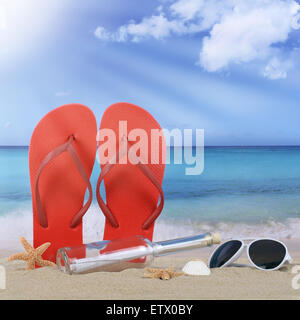 Beach with flip flops sandals and bottle post in summer vacation travel, holidays Stock Photo