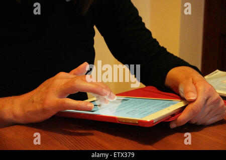 Woman using an ipad digital tablet. Close, hands touching the screen. Stock Photo