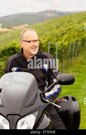 Motorcyclist sitting laughing on the bike Stock Photo