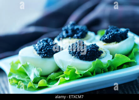 boiled egg with black caviar on plate Stock Photo