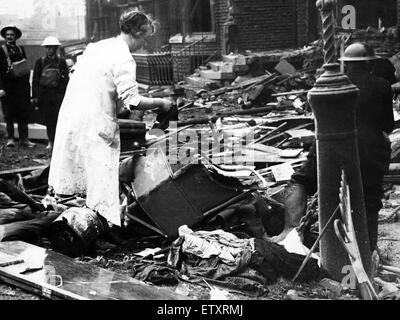 Bomb damage in Liverpool during the Second World War.  A woman searches the wreckage of her home for belongings, after a German raider had dropped bombs on it during a raid to a block of flats in Belvidere Road, Liverpool. 27th September 1940. Stock Photo