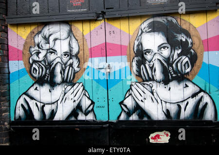 Brick Lane. Street art by Zabou showing two women with masks and spray cans Stock Photo