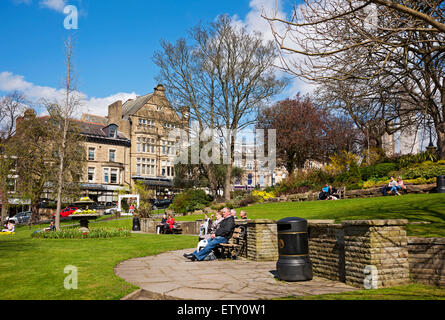 People visitors relaxing sitting sat outside in public garden in spring Montpellier Hill Harrogate North Yorkshire England UK United Kingdom Britain Stock Photo