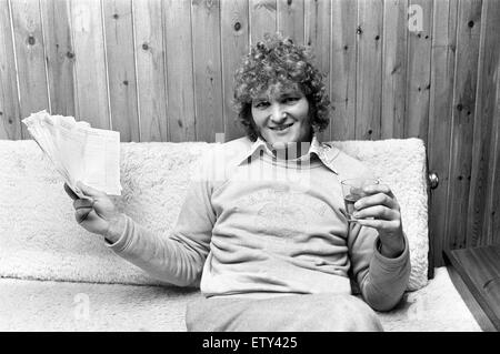 Max Quarterman, the 33 year old plasterer's mate who earns up to £400 a week, pictured relaxing at his home in Burnham, Buckinghamshire. Here he is pictured holding the receipts for his work in one hand and a drink in the other. 5th January 1975. Stock Photo