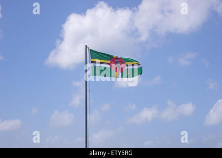 Flag of Dominica on flagpole over blue sky Stock Photo