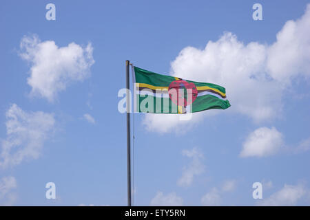 Flag of Dominica on flagpole over blue sky Stock Photo