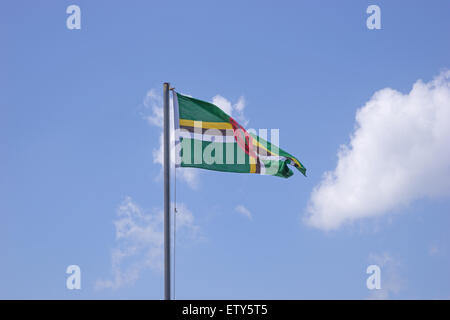 Flag of Dominica on flagpole over blue sky Stock Photo