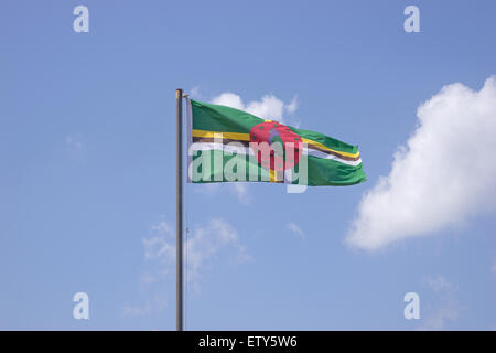 Flag of Dominica on flagpole over blue sky Stock Photo