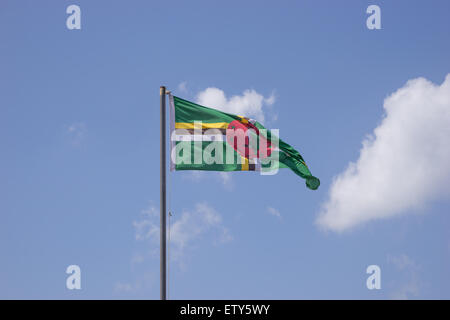 Flag of Dominica on flagpole over blue sky Stock Photo