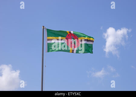 Flag of Dominica on flagpole over blue sky Stock Photo