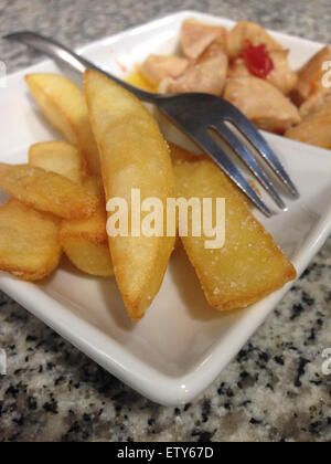 Spanish tapas, patatas with roast chicken over marble bar Stock Photo