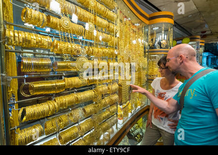 Tourists looking at window display of ornate gold jewellery shop at the Gold Souk in Deira Dubai United Arab Emirates